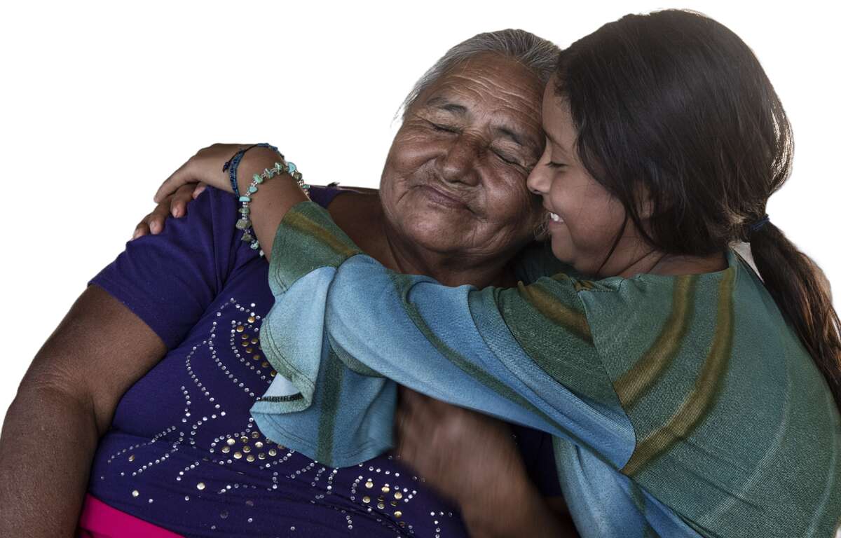 Una mujer de la tercera edad abrazando a una niña. Foto de Jim McKinney.